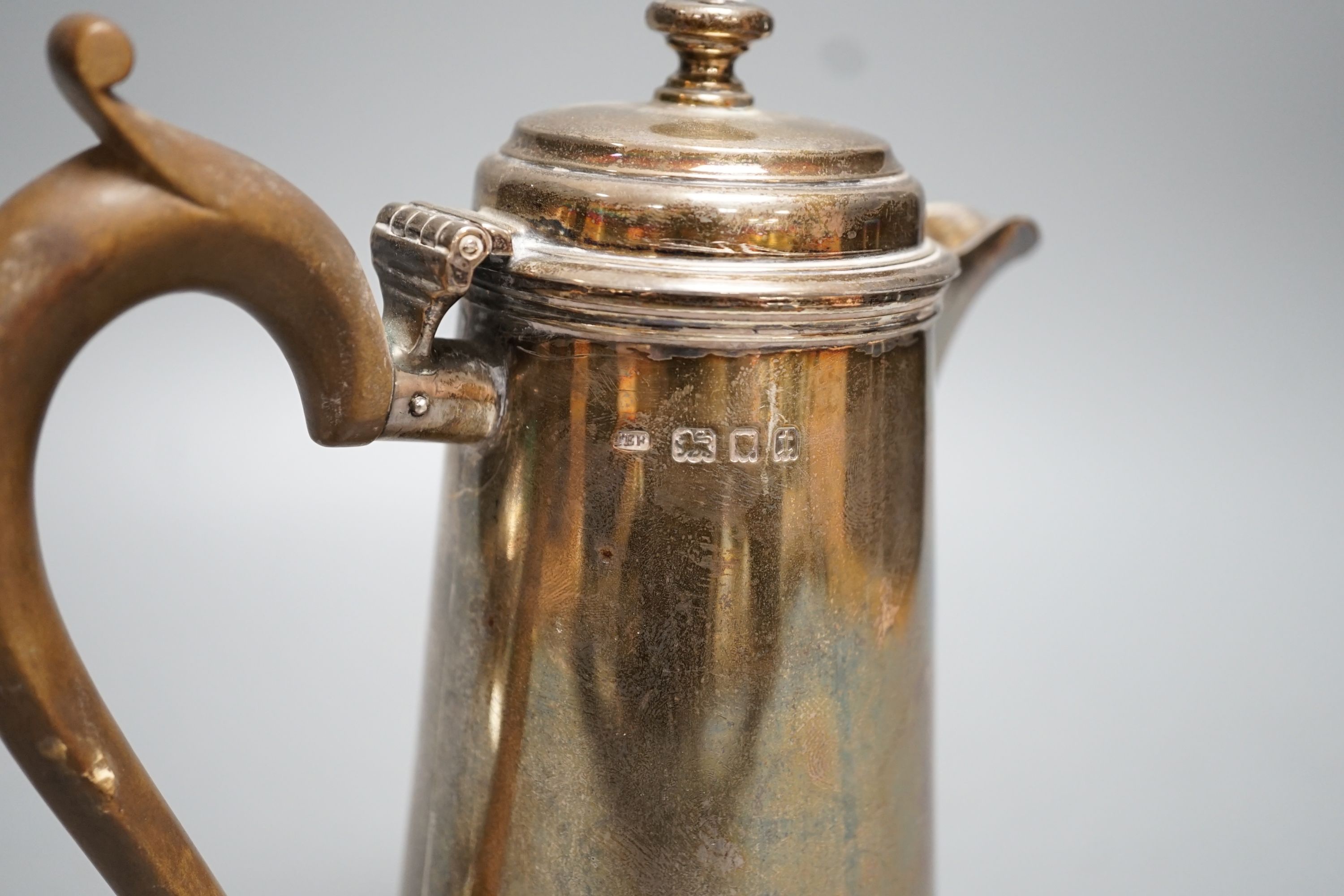 A George V silver hot water pot, London, 1934, gross 15oz and a silver topped glass scent bottle.